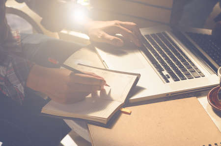 working on laptop, close up of hands of business man,coffee cup,notebook on table