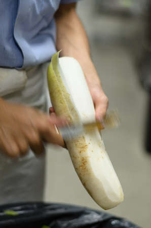 Chef pare radish prepare food in restaurantの写真素材