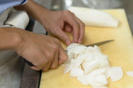 Chef cutting radish prepare food in restaurant,Hand cutting vegetable fast it's skillの写真素材