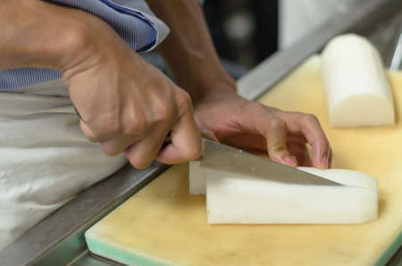 Chef cutting radish prepare food in restaurant,Hand cutting vegetable fast it's skillの写真素材