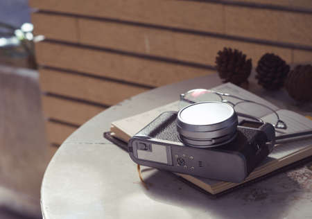 Glasses and camera put on notebook in the deskの写真素材