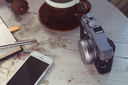 A pen  put on notebook and the camera near coffee cupの写真素材