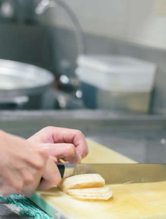 Chef cutting lotus root with skillfully and cutting fastの写真素材