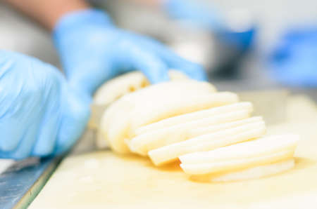 Chef cutting lotus root with skillfully and cutting fastの写真素材