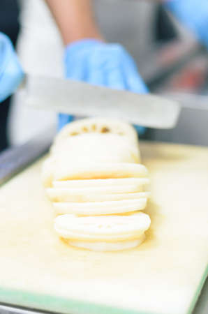Chef cutting lotus root with skillfully and cutting fastの写真素材