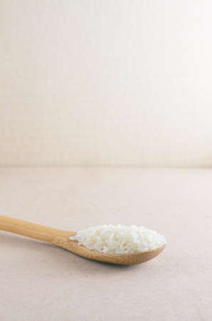 Rice in wooden spoon on backgroundの写真素材