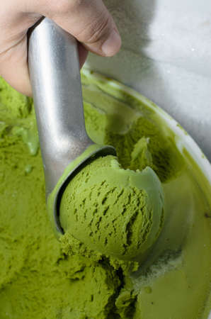 Hand use scoop ice cream in refrigeratorの写真素材