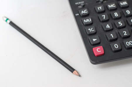 Pencil and calculator on white deskの写真素材