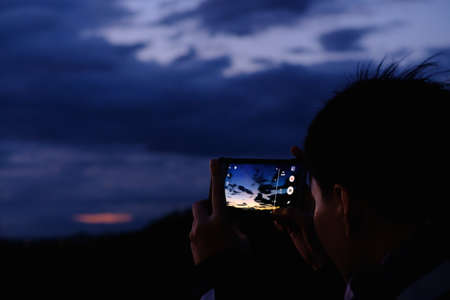 silhouette man taking photos  with mobile phoneの写真素材