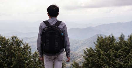 Alone man with backpack looking mountain,tourist traveler on background view hillの写真素材