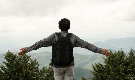 Alone man with backpack looking mountain,tourist traveler on background view hillの写真素材