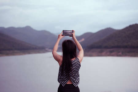 Female traveler photographing mountains at asia,lens flare effect and vintage tone