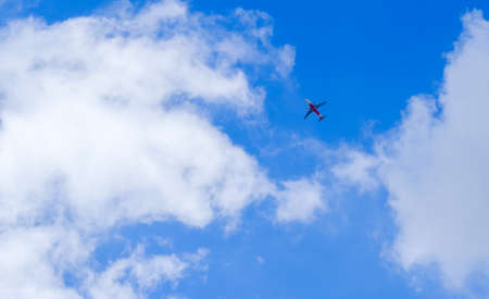 Passenger plane in white clouds and blue skyの写真素材
