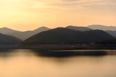 Landscape of mountains and water,sunset light,boat floatingの写真素材