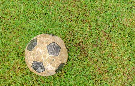 Old football placed on the lawnの写真素材