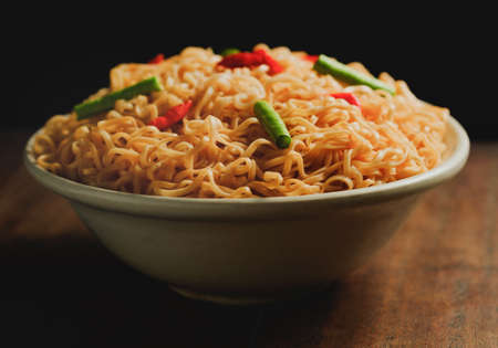 Instant noodles in a bowl place on wooden tableの写真素材