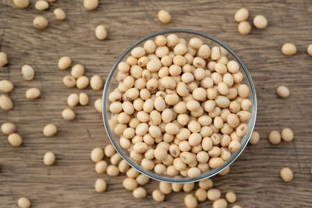 Soybeans are in a cup, placed on a wooden tableの写真素材