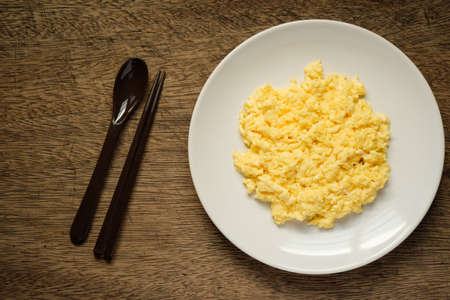 Scramble on a white plate with spoon and chopsticksの写真素材