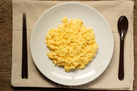 Scramble on a white plate with spoon and chopsticks,copy spaceの写真素材