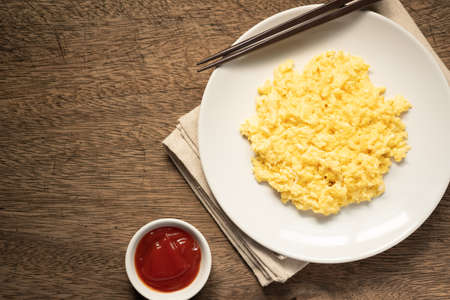 Scramble on a white plate with spoon and chopsticks,ketchup bowl,copy spaceの写真素材