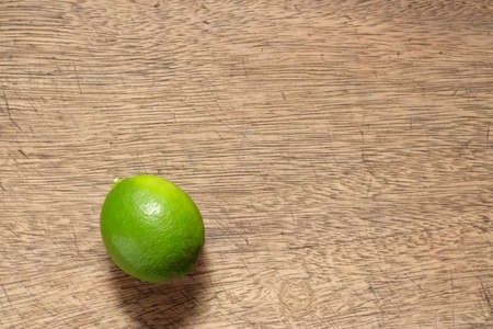 Green lemons placed on a wooden floor,lime with copy spaceの写真素材
