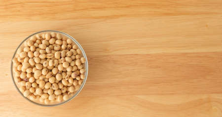 Soybeans are in a cup, placed on a wooden table with copy spaceの写真素材