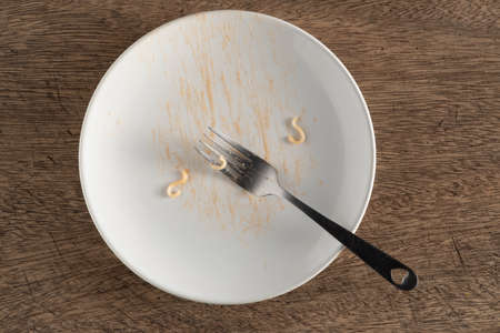 dirty plate with food leftovers. fork and white dishの写真素材