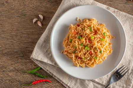 The noodles are in a round white plate placed on a wooden table.copy spaceの写真素材