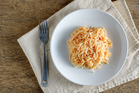 The noodles are in a round white plate placed on a naperyの写真素材