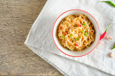 A cup of instant noodles placed on a napery With chilli as ingredients top view noodle and copy spaceの写真素材