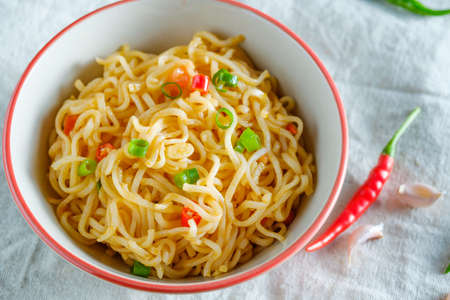 A cup of instant noodles placed on a wooden table With chilli as ingredients top view noodleの写真素材