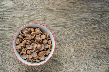 Cereals breakfast in bowl on wooden backdrop with copy space, top viewの写真素材