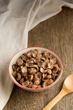 Cereals breakfast cocoa flavor in bowl on wooden backdropの写真素材