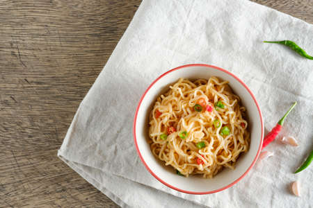 A cup of instant noodles placed on a napery With chilli as ingredients, top view noodle and copy spaceの写真素材