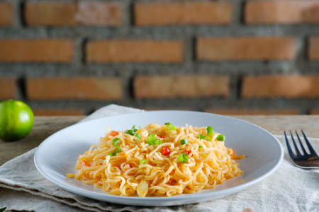 The noodles are in a round white plate placed on a wooden table. noodle conceptの写真素材