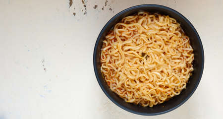 A cup of instant noodles placed on a wooden tableの写真素材