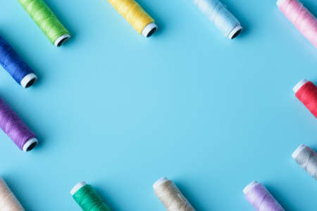 Thread tube colorful on blue background top view and copy spaceの写真素材