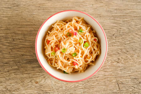 A cup of instant noodles placed on a wooden table With chilli as ingredients top view noodleの写真素材