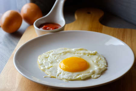 Close up  fried egg is in a white round dish placedの写真素材