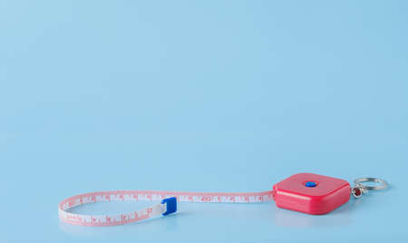 measuring tape on blue background with copy spaceの写真素材