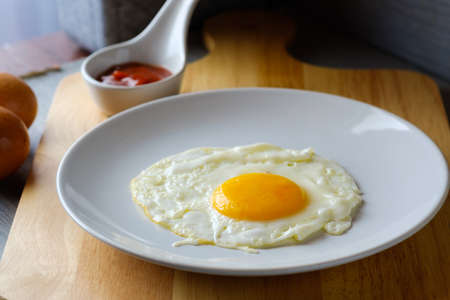 Close up  fried egg is in a white round dish placedの写真素材