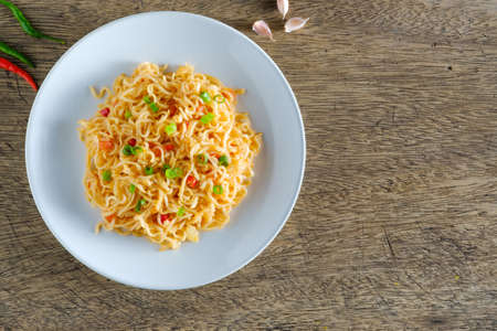 The noodles are in a round white plate placed on a wooden table.copy spaceの写真素材