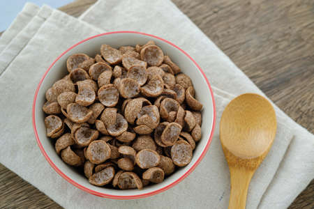Cereals breakfast cocoa flavor in bowl on wooden backdropの写真素材