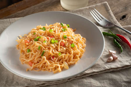 The noodles are in a round white plate placed on a wooden table.noodle concept with copy spaceの写真素材