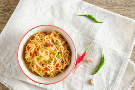 A cup of instant noodles placed on a napery With chilli as ingredients top view noodle and copy spaceの写真素材