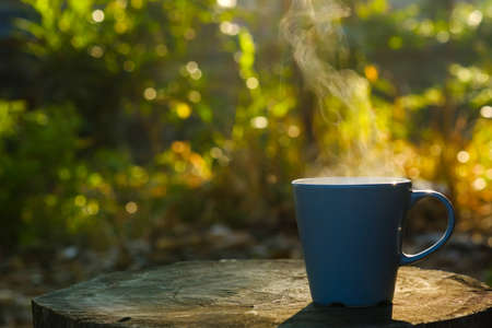 Coffee cup with smoke put on log with copy spaceの写真素材
