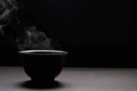 Soup hot in black bowl on wooden table,food steam and copy space ,selective focus.Fresh foods conceptの写真素材