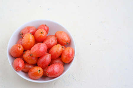 Elaeagnus berry in white bowl on backdrop,copy space,fruit of thailandの写真素材