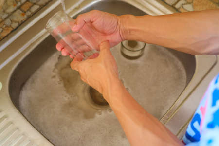 People washing glasses in the sinkの写真素材