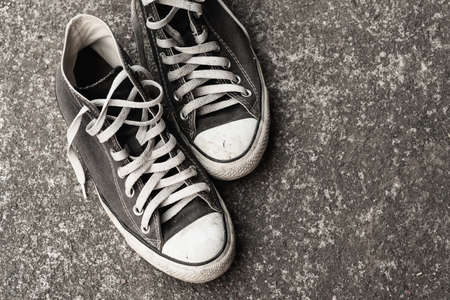 Old sneaker on cement ground .stylish and fashion accessories men wear shoes conceptの写真素材